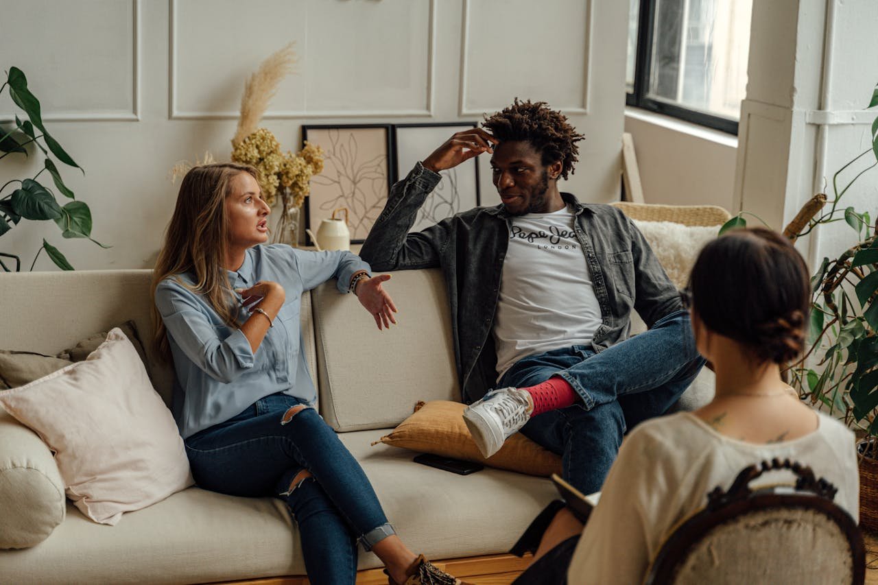 A couple is engaged in a lively conversation during a therapy session with a counselor.