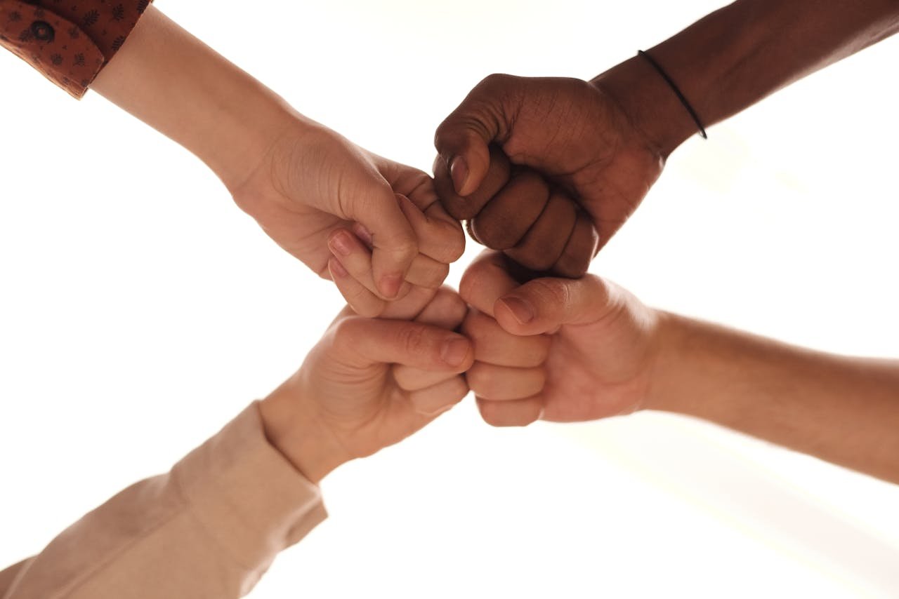 Close-up of diverse hands joining in a fist bump representing unity and teamwork.