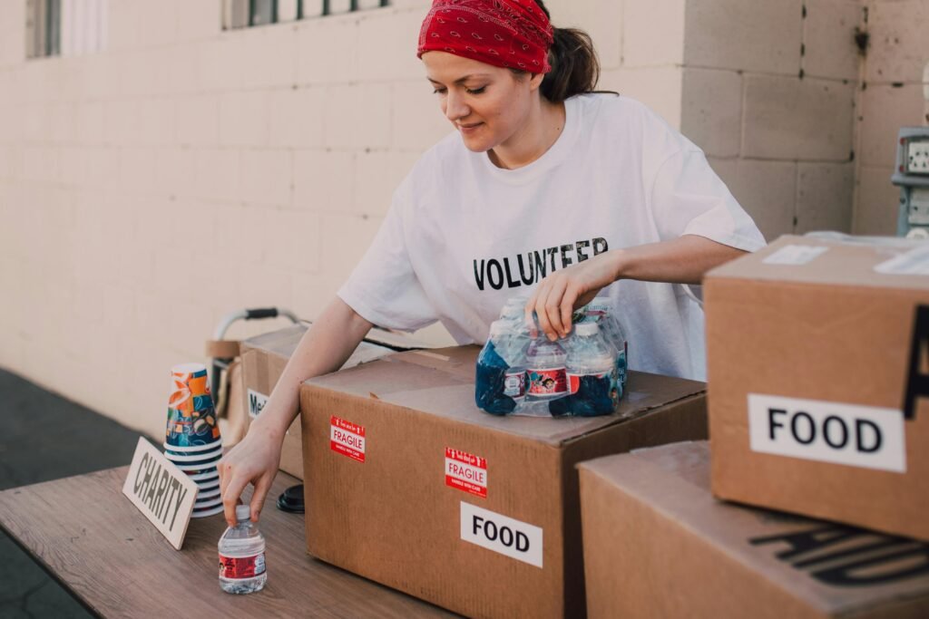 pexels-photo-6646879-6646879 Woman volunteer sorting food and water for charity distribution at aid center.